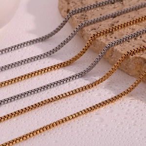 Macro shot of 18K gold and silver box chains showing polished metal texture on stones