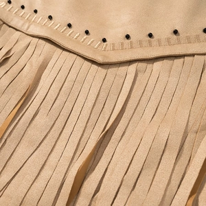 Détail d'une veste en daim camel avec perles noires cloutées et longues franges
