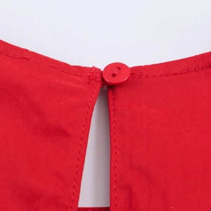 Robe rouge sans manches avec détails de cordon et fermeture à bouton sur tissu tissé