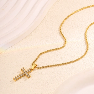 Close-up of a gold-plated twisted rope chain with a micro-pave diamond cross pendant