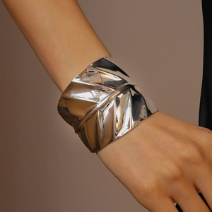 Macro detail of silver geometric wide cuff bracelet with irregular wrinkled texture surface