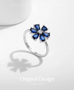 Macro shot of S925 sterling silver ring featuring a blue sapphire flower and S925 hallmark