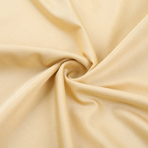 Gros plan détaillé du tissu satiné or champagne avec une texture drapée en spirale