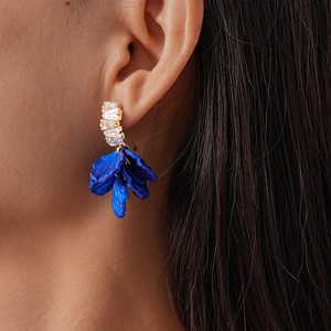 Gros plan de boucles d'oreilles fleurs en acrylique plaqué or avec strass sur mannequin