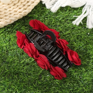 Elegant hair claw clip with red flocked roses on a green grass background