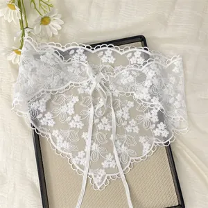 Detail of white floral embroidery lace headband with delicate scalloped edges and ties