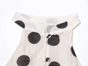 Detail of polka dot top with standing collar and matching buttons on linen fabric