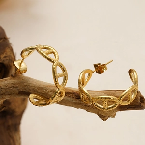 French style 18K gold pleated geometric anchor link earrings on a piece of wood