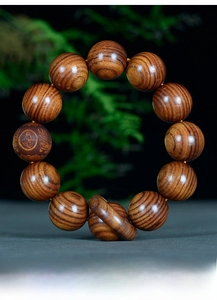 Vue macro de perles en bois Dalbergia haute densité avec finition huilée et gravure fine