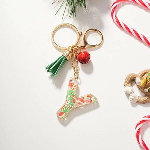 Macro detail of resin letter Y keychain with Christmas sequins, green tassel and bell
