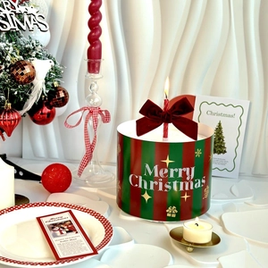 Macro detail of Christmas cake wrap with gold lettering and red velvet ribbon bow