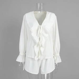 Close-up of white cotton set featuring ruffled deep V-neck and tie-front details