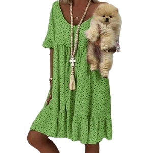 Detalle de vestido verde de lunares con cuello en V y dobladillo con volantes y perro