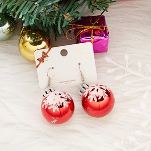 Festive Christmas red ball drop earrings with white snowflakes on white fur background