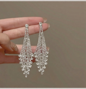 Macro detail of long silver fringe tassel earrings featuring sparkling crystal rhinestones