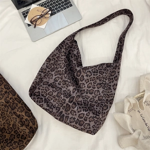 Detail of grey leopard print tote bag with laptop and glasses in a casual setting