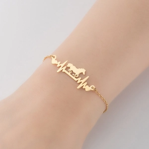 Goldenes Edelstahl-Armband mit Pferd und Herzschlag-Anhänger am Handgelenk der Frau