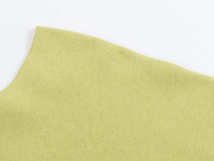 Close-up of lime green V-neck knitwear showing fine texture and fiber details