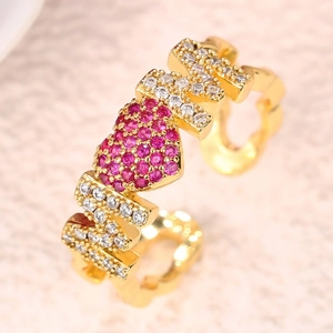 Close-up of golden MOM ring with red heart zircon inlay and pavé set white crystals