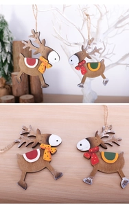 Detail of wooden reindeer ornaments with jute twine hanging on white branches
