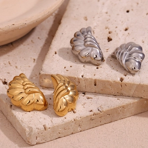 Macro detail of wave patterned 18K gold and silver plated stainless steel stud earrings