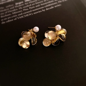 Détail de boucles d'oreilles vintage dorées avec perles blanches et perles de résine