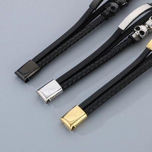Detail of multilayer braided leather bracelets with skull charms and magnetic clasps