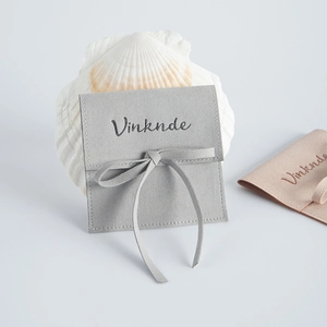 Detail of minimalist microfiber suede jewelry pouches with ties and shell decoration