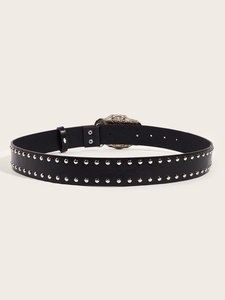 Detail of a black punk leather belt with double-row silver studs and vintage engraved buckle
