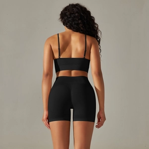 Detail view of seamless cross-back sports bra and high-waist yoga shorts in black