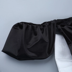 Détail macro des plis ondulés élégants et du drapé soyeux sur la robe en satin noir