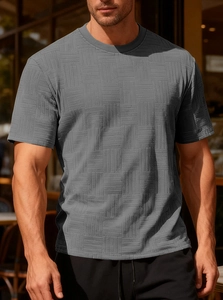 Detail of grey slim fit T-shirt with square textured fabric on a male model outdoors