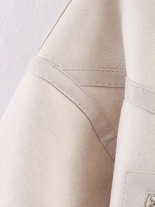 Close-up of high-quality double-stitching and suede texture on white biker jacket