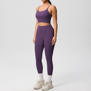 Side view of dark purple yoga set featuring thin strap sports bra and high waist leggings