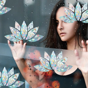 Detailed holographic lotus window stickers being applied to glass with rainbow light effect