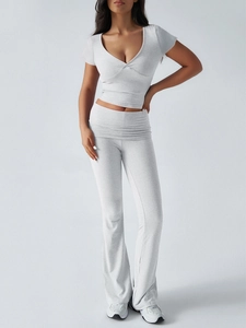 Vue détaillée d'un crop top à col en V blanc et d'un pantalon évasé sur un mannequin