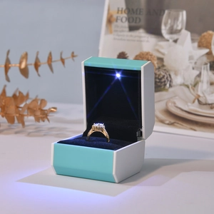 Octagonal Tiffany blue jewelry box with LED light illuminating a gold diamond ring inside