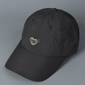 Macro view of black nylon baseball cap featuring green heart-shaped Family embroidery