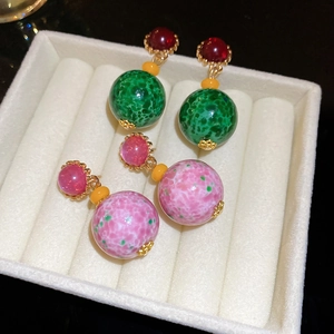 Detail of vintage round resin drop earrings with marble textures and gold metal accents
