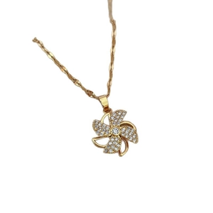 Luxury gold spinning windmill pendant necklace with sparkling crystals on white background