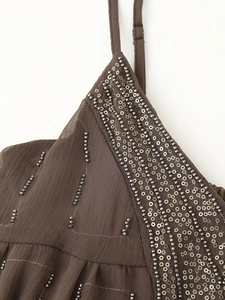 Detail of dark brown dress with intricate sequin and tube bead embroidery on fabric