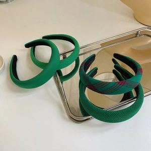 Selection of green plaid and corduroy padded headbands on a metallic tray