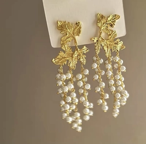 Detailed view of gold leaf earrings with elegant multi-layer faux pearl tassel chains