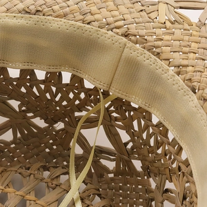 Close-up of handwoven straw hat interior with elastic sweatband and fine ribbon detail