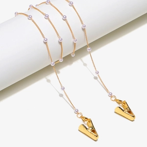 Detail of gold pearl chain with alligator clips for masks or glasses on a display stand
