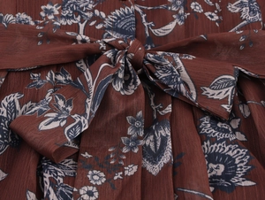 Detailed close-up of chiffon floral dress featuring waist tie bow and crepe texture