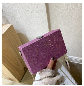 Detail of purple glitter clutch bag with holographic star sequins and silver metal clasp