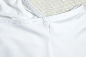 Detailed close-up showing precision double-needle stitching on white elastic knit fabric