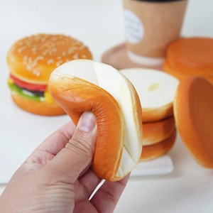 Realistic slow rebound PU burger squishy toy being pressed on a wooden tray