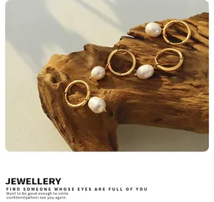 Detail of French vintage gold hoops with natural freshwater pearls on a wooden base